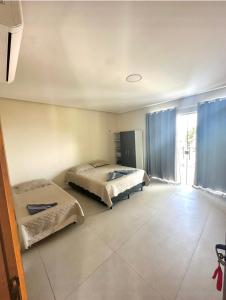 a bedroom with two beds and a large window at Casa Amarilla Alter in Alter do Chao +35 photos