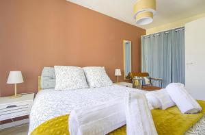 a bedroom with a white bed with a yellow blanket at Le Cocon de Nuit Normande in Étretat