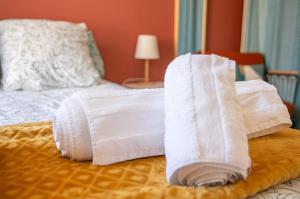 two rolls of white towels on a bed at Le Cocon de Nuit Normande in Étretat