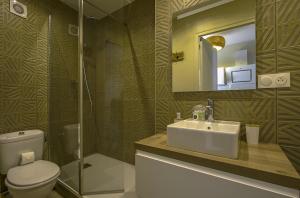 a bathroom with a sink and a toilet and a mirror at Le Cocon de Nuit Normande in Étretat