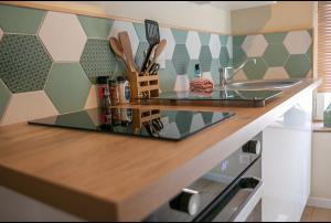 a kitchen counter with a glass counter top with utensils at Le Cocon de Nuit Normande in Étretat