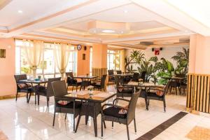 a restaurant with tables and chairs and plants at Greenvale Hotel 1BR Along Kamiti Road in Kiambu