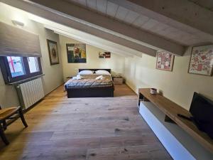 a bedroom with a bed and a television in it at LA CASA Di Nonno Angelo in Capo di Ponte