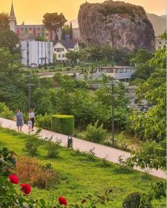 a group of people walking down a sidewalk at Bloom House Përmet in Përmet