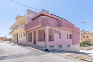 a pink building on the side of a street at B&B della stazione in Pachino