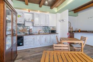 a kitchen with white cabinets and a wooden table at B&B della stazione in Pachino