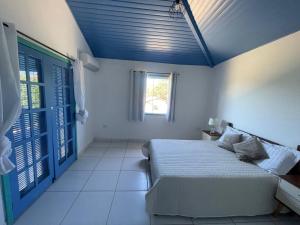 a bedroom with a bed with a blue ceiling at Recanto dos Valles in Búzios