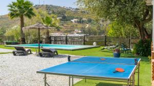a ping pong table in a backyard with a pool at Casa Corazón 44 Torrox by Ruralidays in Torrox
