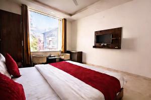 a bedroom with a large bed with a large window at Foxoso Heights, Tapovan in Rishīkesh