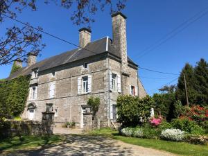 an old stone house with two chimneys at Le Logis du GAST Chambre Taupe in Le Gast