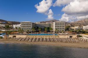 a resort on the beach with chairs and a pool at Alimounda Mare Hotel in Karpathos