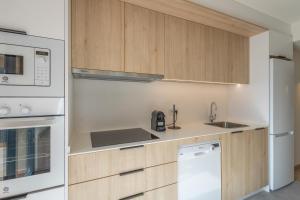 a kitchen with white appliances and wooden cabinets at Be1960 quart in Bagá