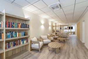a library with chairs and tables and bookshelves at Be1960 quart in Bagá
