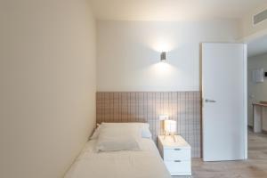 a bedroom with a bed and a white wall at Be1960 quart in Bagá