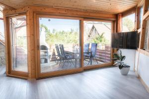 a screened porch with sliding glass doors and a flat screen tv at Wohnung am Bodensee in Moos
