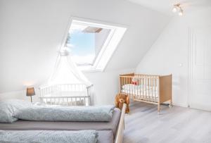a bedroom with two cribs and a large window at Wohnung am Bodensee in Moos