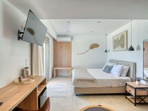 a bedroom with a bed and a desk in it at Starlight Ocean View in Kardamaina