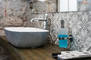 a bathroom sink with a soap dispenser on a counter at Assos Behram Special Class Hotel Adults Only in Behramkale +84 photos