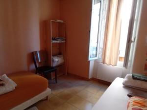 a room with a bed and a chair and a window at Appartement 2chb et balcon au centre de Nyons in Nyons