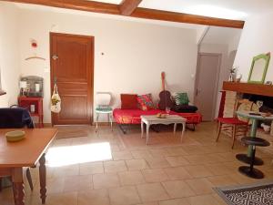 a living room with a red couch and a table at Appartement 2chb et balcon au centre de Nyons in Nyons