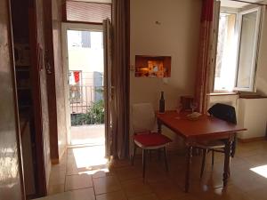 a dining room with a table and chairs and a window at Appartement 2chb et balcon au centre de Nyons in Nyons +2 photos