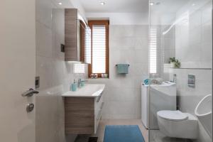 a white bathroom with a sink and a toilet at Villa Peragro in Dubrovnik