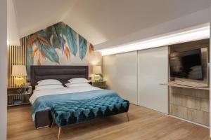 a bedroom with a large bed with a large painting on the wall at Villa Peragro in Dubrovnik