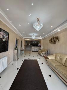 a large living room with couches and a chandelier at Hotel Terra Iasi in Iaşi