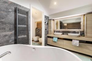 a bathroom with a white tub and two sinks at Villa Peragro in Dubrovnik +64 photos