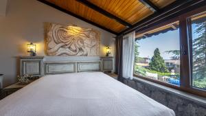 a bedroom with a bed and a large window at Assos Behram Special Class Hotel Adults Only in Behramkale