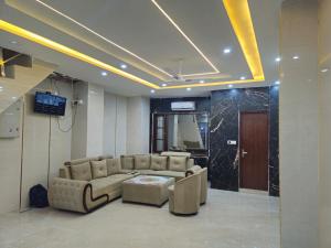 a living room with a couch and a table and a television at Royal Guest House in Jammu