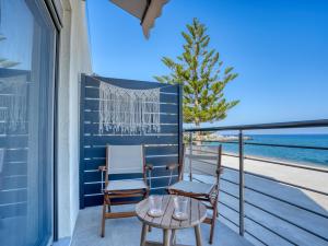 a balcony with two chairs and a table and a view of the ocean at Starlight Ocean View in Kardamaina