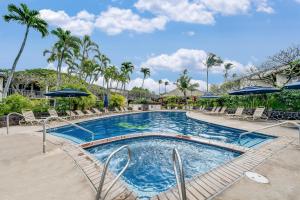 a swimming pool with chairs and umbrellas at a resort at Napili Shores D126 · NSD126 Cozy Studio Steps to Beach in Kahana