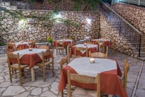 a restaurant with tables and chairs and a stone wall at Olive Tree-Member of My Villas Hospitality in Lefkada