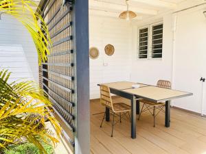 a table and two chairs on a porch with a table at Emeraude tropicale in Goyave