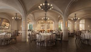 a dining room with tables and chairs and chandeliers at The Nora Hotel in West Palm Beach