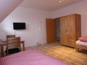 a bedroom with a bed and a desk and a tv at Ferienhof von Hammel in Sevelten