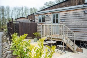 eine Holzhütte mit Terrasse und Zaun in der Unterkunft Digby's Hut in Foolow