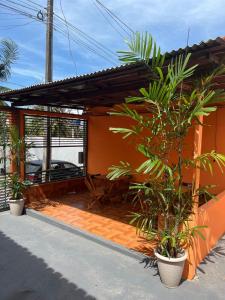 a house with a patio with plants in front of it at Pousada Fonseca in Salinópolis