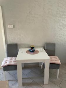 a white table and two chairs with a bowl on it at Teodora in Banja Koviljača +10 photos