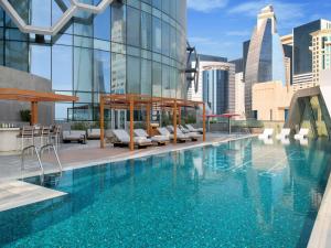 a pool on the rooftop of a building at Swissôtel Corniche Park Towers Doha in Doha