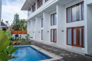 a house with a swimming pool in front of it at Patera Living in Sempidi