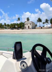 a steering wheel of a boat in front of a beach at Pousada Nova Flor de Lotus Suites in Tamandaré