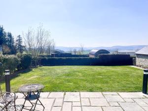 a patio with a table and chairs in a yard at Mountain View Pod in Rhayader
