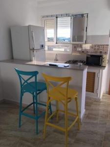 a kitchen with two chairs and a counter with a sink at Haouaria PANTELLERIA in Sidi Amor +5 photos