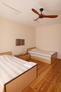 two beds in a room with a ceiling fan at Wings of Tatev Private Villa in Halidzor +80 photos