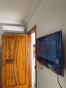 a flat screen tv on a wall next to a door at Haouaria PANTELLERIA in Sidi Amor