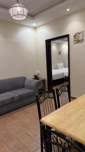 a living room with a couch and a table and a mirror at ريف سويت للشقق المخدومة in Al Namas