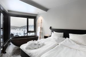 a bedroom with a large bed and a bath tub at Norefjell Ski & Spa in Noresund +68 photos