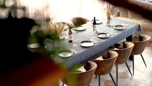 a dining room table with plates and wine bottles at Metsapiiga Talu in Vilina